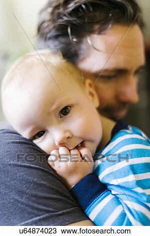 Stock Image - Father embracing son (12-17 months). Fotosearch