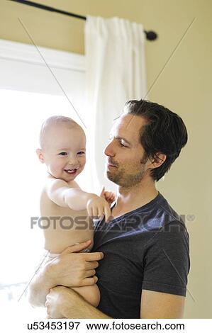 Stock Photo - Father embracing son (12-17 months). Fotosearch