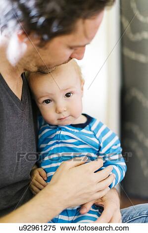 Stock Photography - Father embracing son (12-17 months). Fotosearch