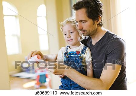 Stock Image - Father giving son (4-5) antibiotic. Fotosearch