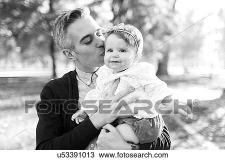 Stock Image - Father kissing daughter (12-17 months). Fotosearch