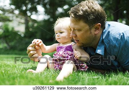 Father playing with baby girl (12-17 months) in backyard View Large Photo Image Stock Photo - Father playing with baby girl (12-17 months) in backyard. Fotosearch