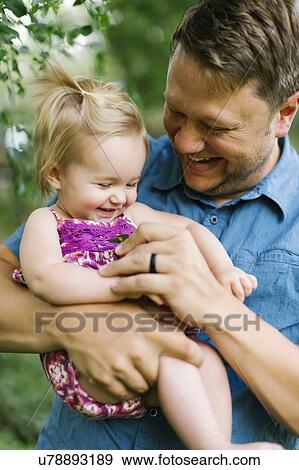 Father playing with baby girl (12-17 months) in backyard View Large Photo Image Stock Photo - Father playing with baby girl (12-17 months) in backyard. Fotosearch