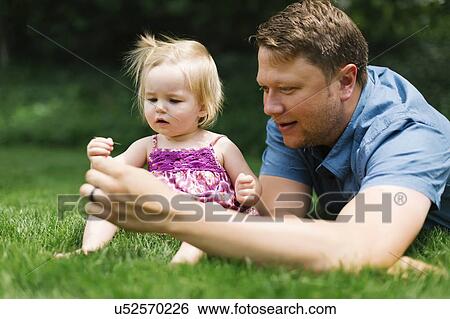 Father playing with baby girl (12-17 months) in backyard View Large Photo Image Stock Photograph - Father playing with baby girl (12-17 months) in backyard. Fotosearch