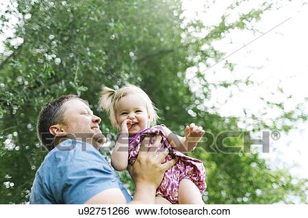 Father playing with baby girl (12-17 months) in backyard View Large Photo Image Stock Photograph - Father playing with baby girl (12-17 months) in backyard. Fotosearch