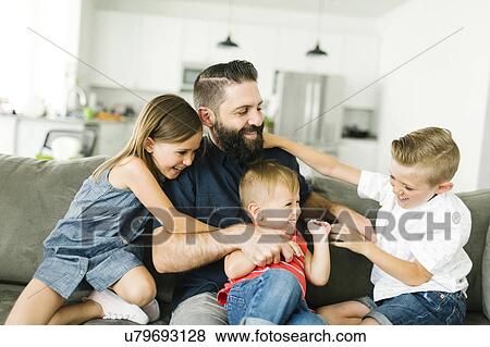 Stock Photo - Father playing with his three children (2-3, 6-7). Fotosearch
