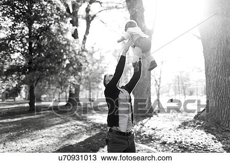 Father throwing daughter (12-17 months) up in air in park View Large Photo Image Stock Image - Father throwing daughter (12-17 months) up in air in park. Fotosearch