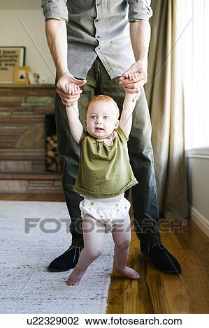 Stock Image - Father walking with daughter (12-17 months). Fotosearch