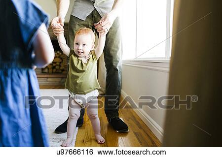 Stock Photograph - Father walking with daughter (12-17 months). Fotosearch