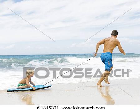 Father with son (4-5) playing at beach View Large Photo Image Stock Image - Father with son (4-5) playing at beach. Fotosearch