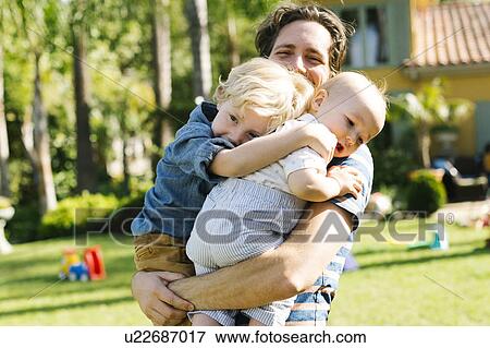 Father with two sons (12-17 months, 4-5) playing in backyard View Large Photo Image Stock Photo - Father with two sons (12-17 months, 4-5) playing in backyard. Fotosearch
