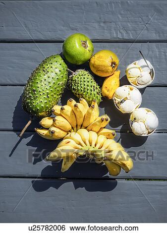 Stock Photograph - Fruit and ice creams on black floor. Fotosearch
