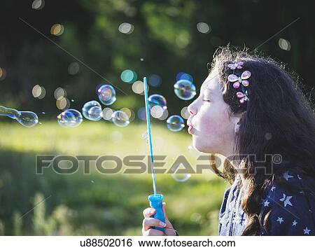 Girl (10-11) blowing bubbles View Large Photo Image Stock Photograph - Girl (10-11) blowing bubbles. Fotosearch