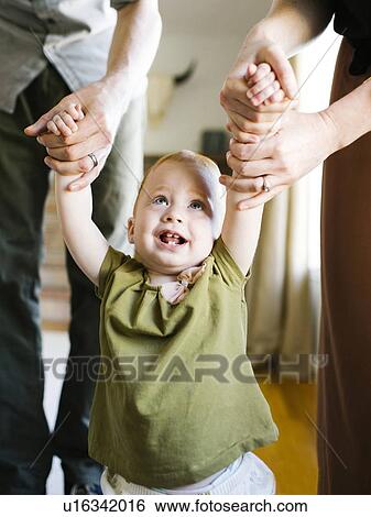 Stock Photograph - Girl (12-17 months) learning to walk. Fotosearch