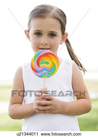 Girl (4-5) holding colorful lollipop View Large Photo Image Stock Image - Girl (4-5) holding colorful lollipop. Fotosearch