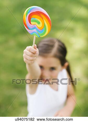 Girl (4-5) holding colorful lollipop View Large Photo Image Stock Image - Girl (4-5) holding colorful lollipop. Fotosearch