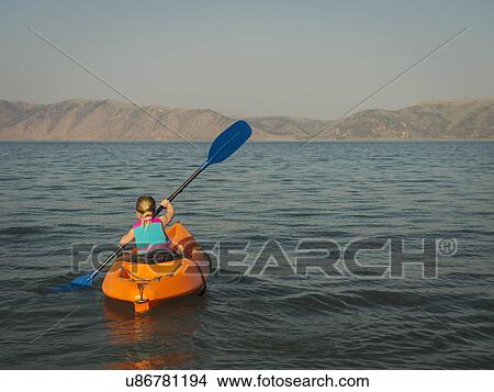 Picture - Girl (4-5) kayaking on lake. Fotosearch