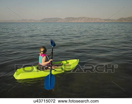 Stock Image - Girl (4-5) kayaking on lake. Fotosearch