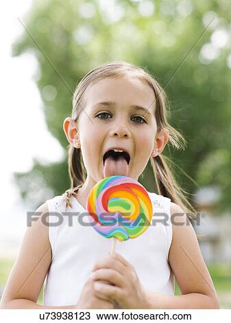 Girl (4-5) licking colorful lollipop View Large Photo Image Stock Image - Girl (4-5) licking colorful lollipop. Fotosearch