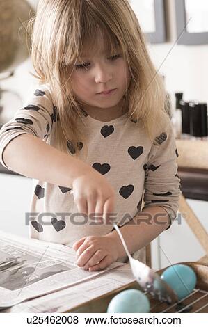 Stock Photo - Girl (4-5) making colored Easter eggs. Fotosearch