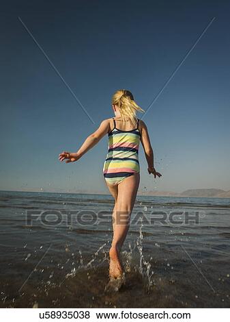 Stock Photo - Girl (4-5) running into lake. Fotosearch