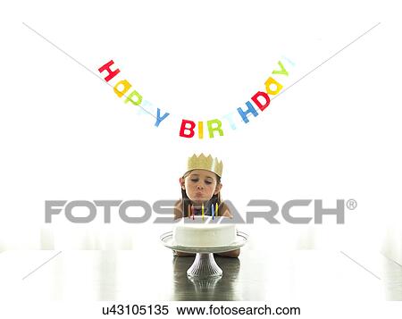Girl (6-7) in paper crown blowing candles on birthday cake View Large Photo Image Stock Photography - Girl (6-7) in paper crown blowing candles on birthday cake. Fotosearch