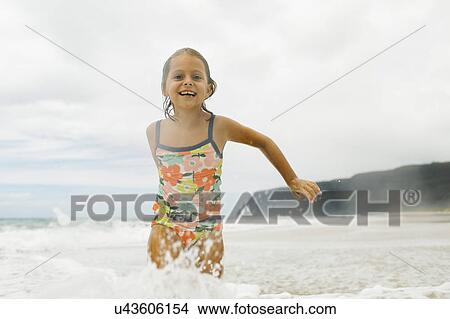 Picture - Girl (6-7) playing in sea. Fotosearch
