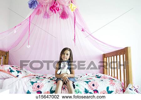 Girl (6-7) sitting on bed View Large Photo Image Stock Image - Girl (6-7) sitting on bed. Fotosearch
