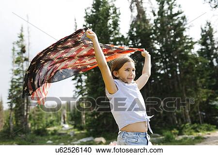 Girl (8-9) holding us flag in forest View Large Photo Image Stock Image - Girl (8-9) holding us flag in forest. Fotosearch