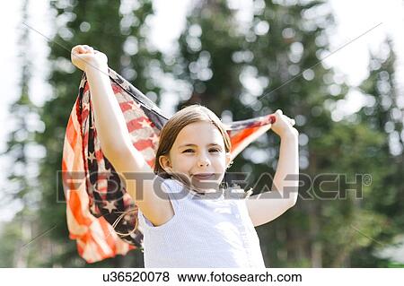 Girl (8-9) holding us flag in forest View Large Photo Image Stock Photo - Girl (8-9) holding us flag in forest. Fotosearch