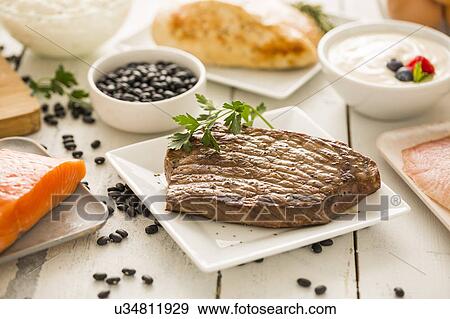 Stock Photo - Grilled chicken served with black beans, yogurt and cottage cheese. Fotosearch