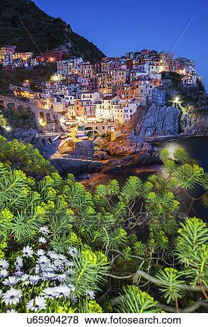 Italy, Liguria, Manarola at dusk with tree branch in foreground View Large Photo Image Stock Photo - Italy, Liguria, Manarola at dusk with tree branch in foreground. Fotosearch
