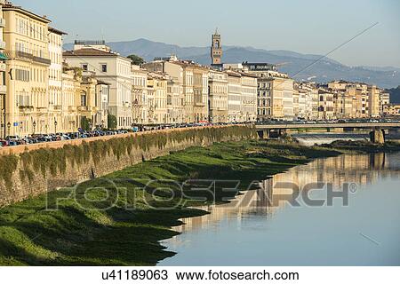 Stock Image - Italy, Tuscany, Florence, Cityscape reflected in Arno River. Fotosearch