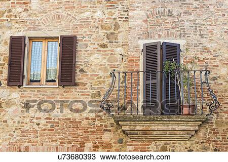 Italy, Tuscany, Montepulciano, Stony and brick facade of house with carved metal balcony and latticed sun blinds View Large Photo Image Stock Image - Italy, Tuscany, Montepulciano, Stony and brick facade of house with carved metal balcony and latticed sun blinds. Fotosearch