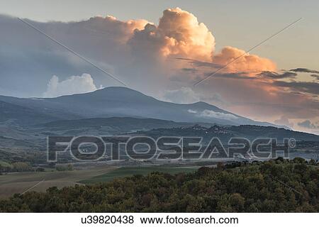 Stock Photo - Italy, Tuscany, San Quirico D'orcia, Landscape in evening with flaming clouds in sky. Fotosearch