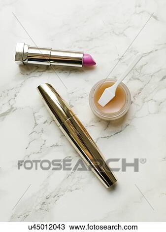 Stock Image - Lipstick and mascara on marble background. Fotosearch
