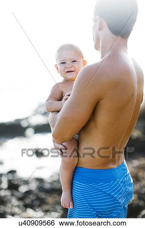 Man holding baby son (18-23 months) View Large Photo Image Stock Photograph - Man holding baby son (18-23 months). Fotosearch