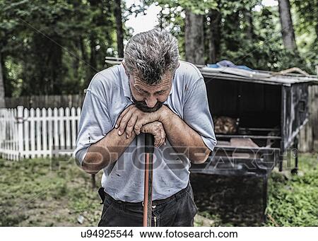 Picture - Man working by traditional Bosnian cook hut in backyard. Fotosearch
