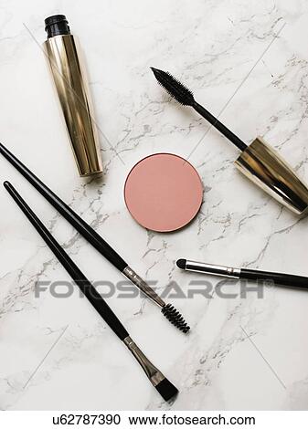 Stock Image - Mascara and make-up brushes on marble background. Fotosearch