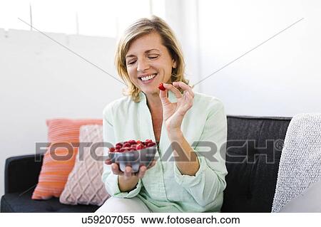 Mature woman eating raspberries View Large Photo Image Stock Photography - Mature woman eating raspberries. Fotosearch