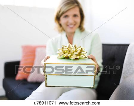 Stock Image - Mature woman giving gift. Fotosearch