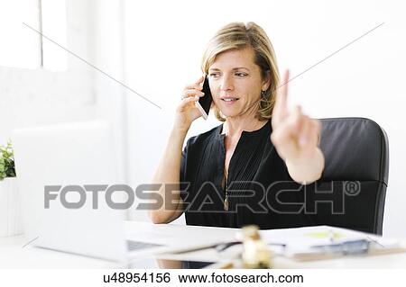 Stock Photograph - Mature woman talking on mobile phone. Fotosearch