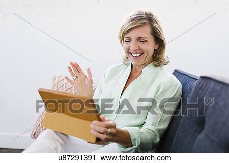 Stock Image - Mature woman using tablet. Fotosearch
