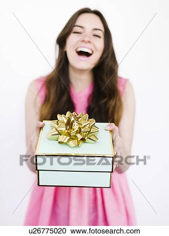 Mid adult woman holding gift box and laughing View Large Photo Image Stock Image - Mid adult woman holding gift box and laughing. Fotosearch