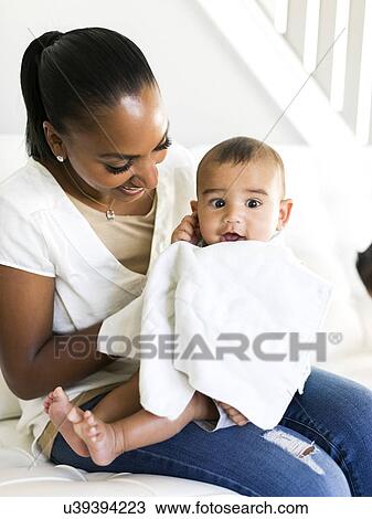 Mother and baby boy (2-5 months) sitting on sofa View Large Photo Image Stock Image - Mother and baby boy (2-5 months) sitting on sofa. Fotosearch