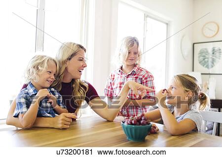Mother and children (4-5, 6-7, 8-9) eating grapes View Large Photo Image Stock Image - Mother and children (4-5, 6-7, 8-9) eating grapes. Fotosearch