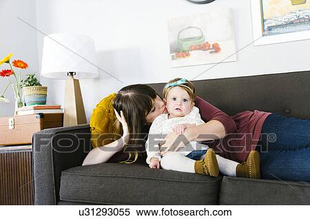 Mother and daughter (12-17 months) on sofa View Large Photo Image Stock Photography - Mother and daughter (12-17 months) on sofa. Fotosearch