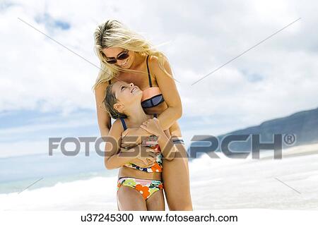 Mother and daughter (6-7) embracing on beach View Large Photo Image Stock Image - Mother and daughter (6-7) embracing on beach. Fotosearch
