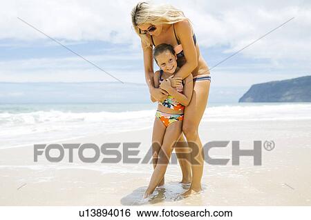 Mother and daughter (6-7) embracing on beach View Large Photo Image Stock Photograph - Mother and daughter (6-7) embracing on beach. Fotosearch