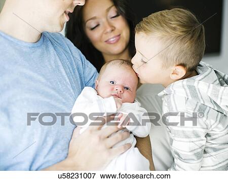 Stock Photo - Mother and father carrying son (4-5) and daughter (0-1 months). Fotosearch